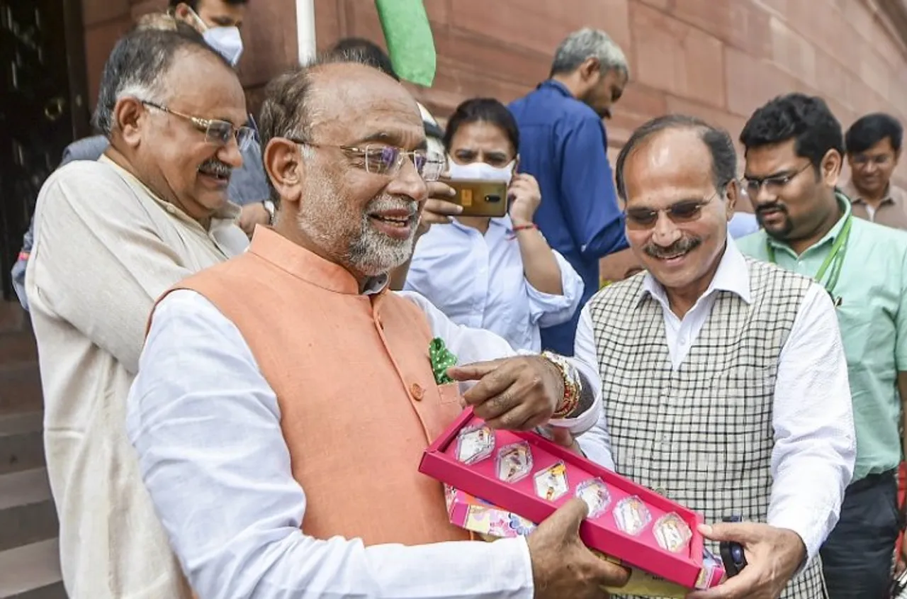 BJP MP Vijay Goel interacts with Congress MP Adhir Ranjan Chowdhury while distributing rakhis with pictures of freedom fighters at Parliament House complex during ongoing Monsoon Session, in New Delhi