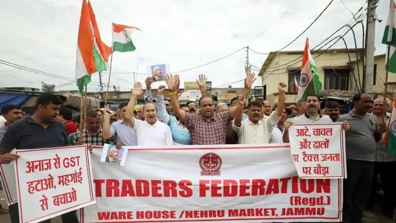 Traders Federation Ware House-Nehru Market members hold National flags as they raise slogans during a protest demanding the withdrawal of 5 per cent GST on food grains, in Jammu 