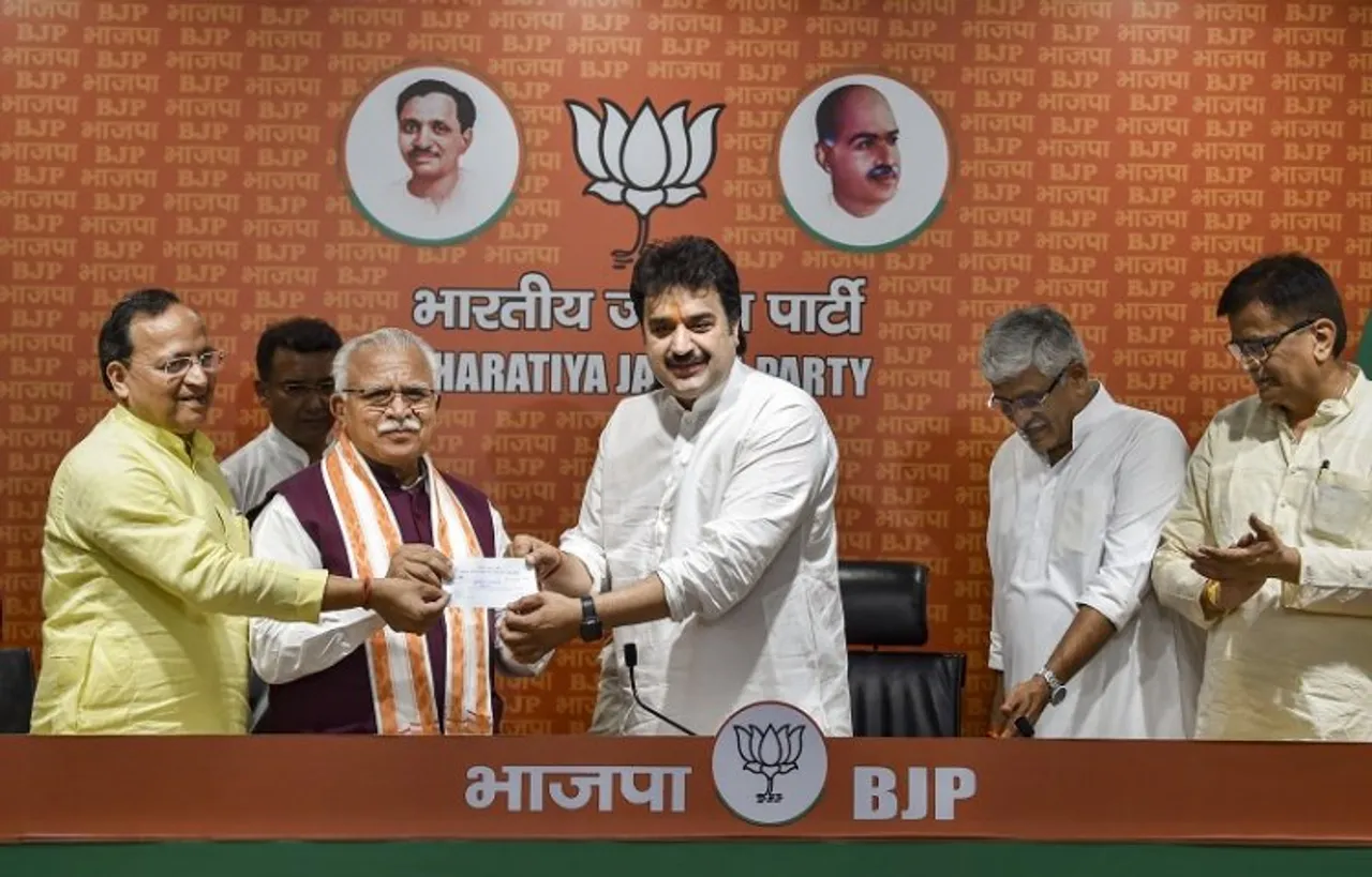 Former Congress leader Kuldeep Bishnoi receives membership slip from BJP National General Secretary Arun Singh and Haryana CM Manohar Lal as he along with his wife Renuka (unseen) joins the Bharatiya Janata Party, at the party headquarters, in New Delhi
