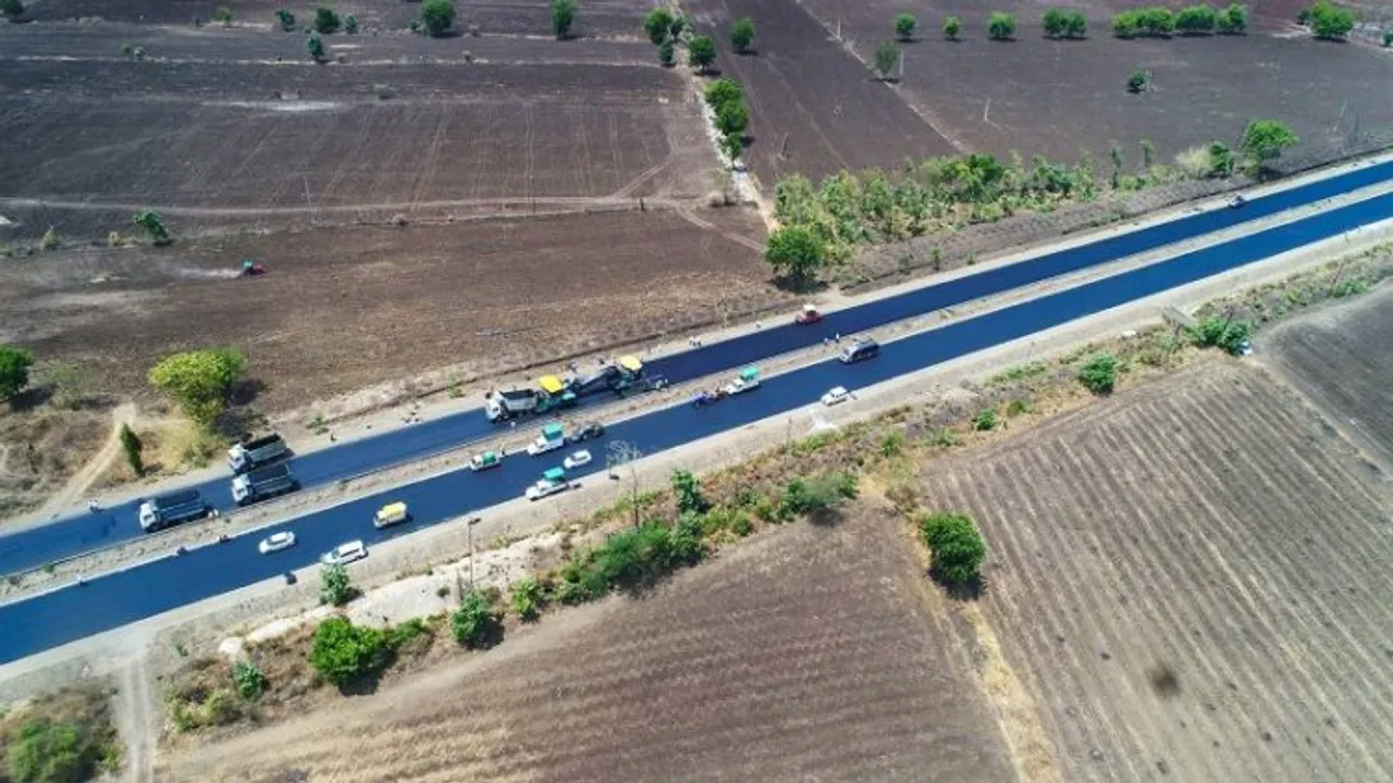 Workers construct 75 Km single lane continuous Bituminous Concrete road on NH-53 between Amravati to Akola