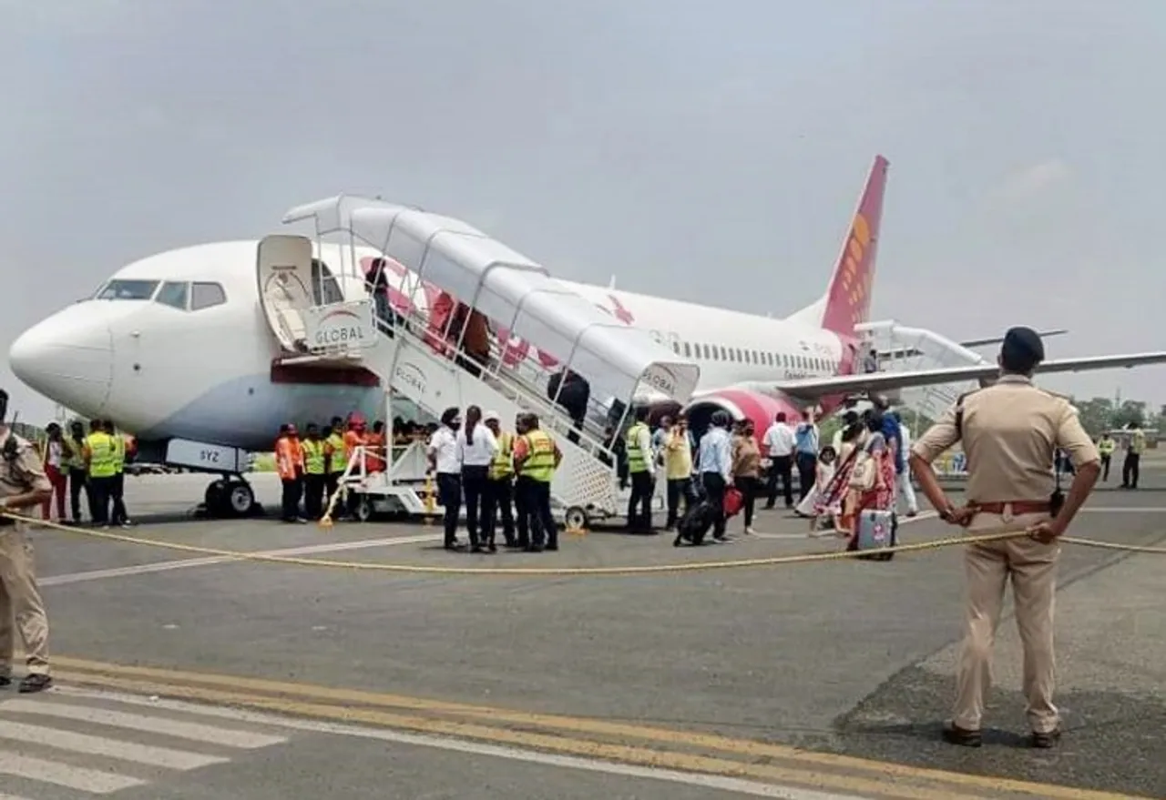 Passengers come out of the Delhi-bound SpiceJet airplane following its emergency landing after it caught fire mid-air, at Jai Prakash Narayan airport, in Patna