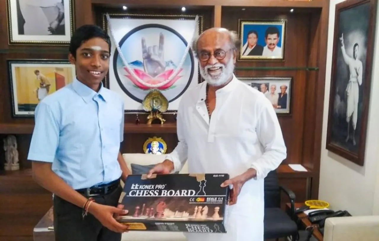 Veteran actor Rajinikanth receives a chessboard from Chess Grandmaster R. Praggnanandhaa during their interaction, ahead of the 44th International Chess Olympiad