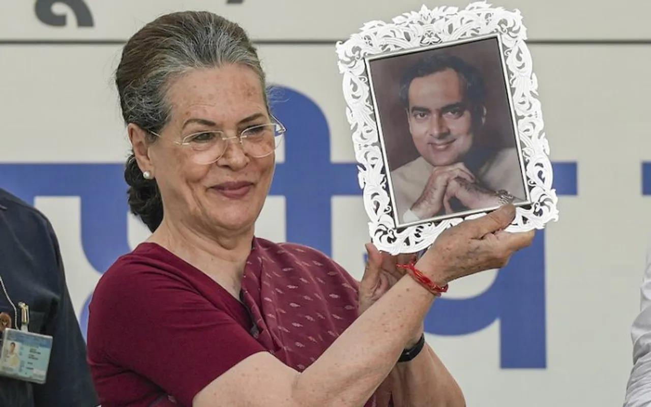 Sonia Gandhi showing a portrait of Rajiv Gandhi presented to her by Mallikarjun Kharge at AICC Headquarters on Wednesday
