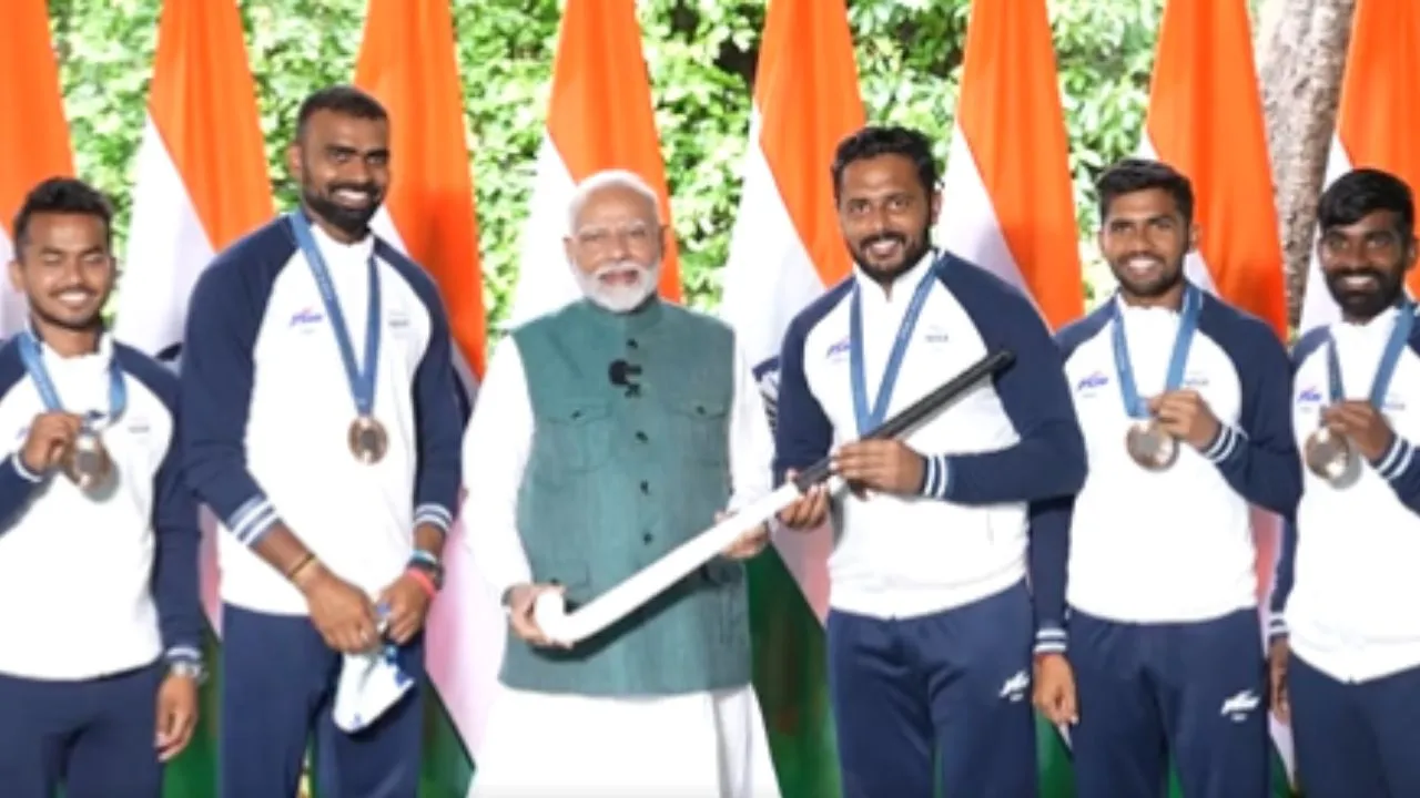 Olympians give gifts to Narendra Modi while meeting at his residence