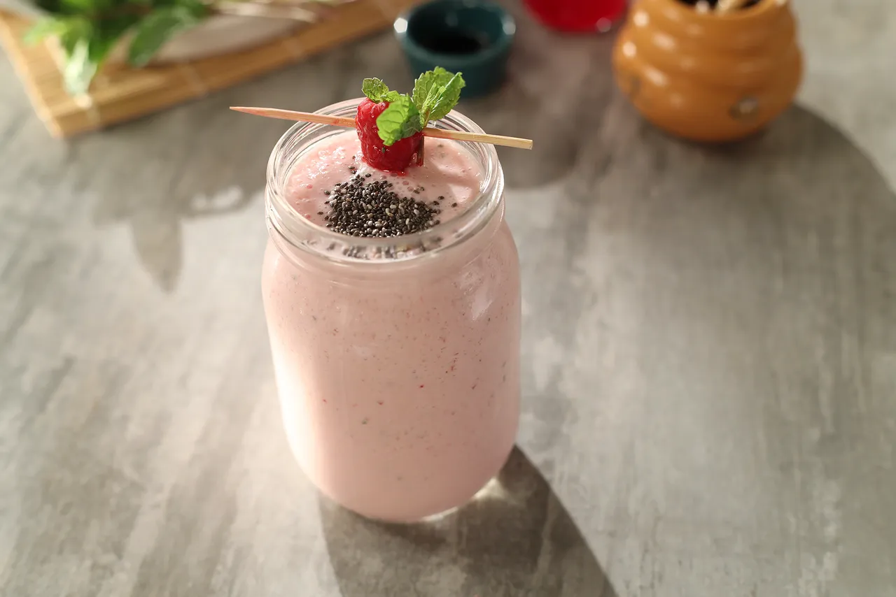 15-20 fresh raspberries, frozen + for garnish 4½ tbsps raspberry crush 2½ cups yogurt 2 tsps vanilla essence 4 tbsps honey 15-20 fresh mint leaves Ice cubes as required 1½ cups milk Mint sprig for garnish Chia seeds for garnish  Method  1.	In a blender jar, add yogurt, raspberry crush and vanilla essence. Add honey, fresh raspberries, mint leaves, ice cubes and milk and blend to a smooth mixture. 2.	Transfer the mixture into a serving glass. Garnish with fresh frozen raspberries and mint sprig and chia seeds.