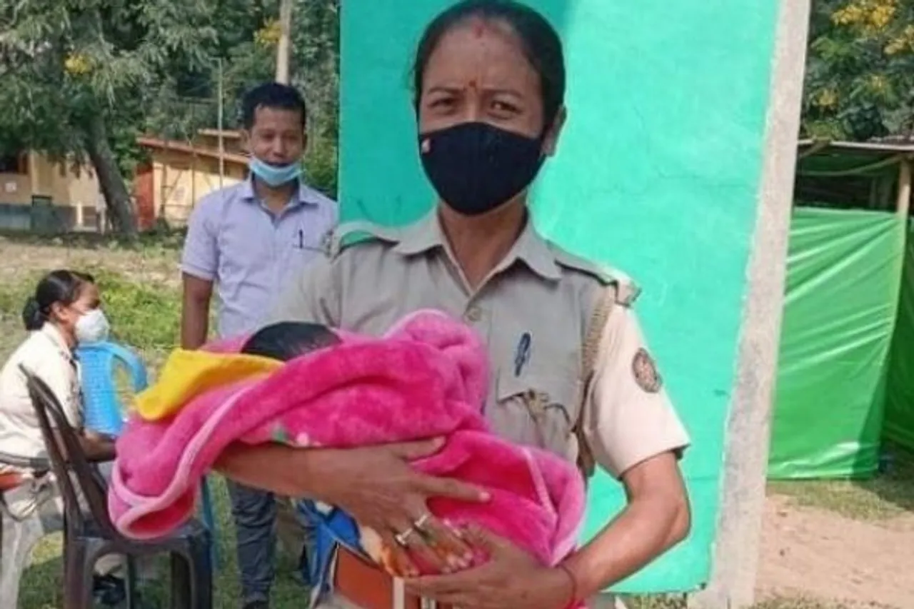 Assam police officer holding baby