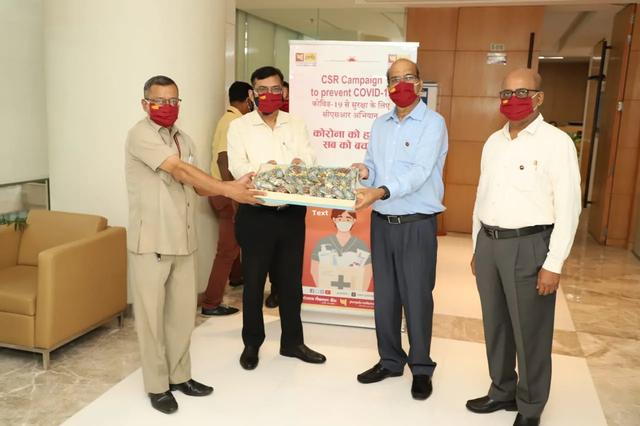 Rajesh Kumar Yaduvanshi, Shri Sanjay Kumar and Shri Vijay Dube distributing prevention materials to the facility management staff at the PNB Head office, New Delhi