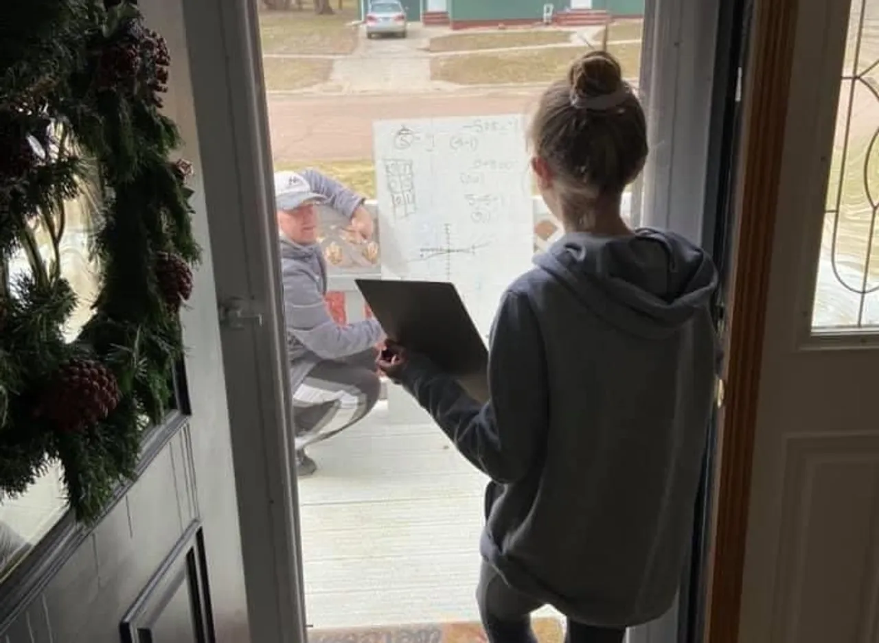 Math teacher solving doubts of a student at her house porch