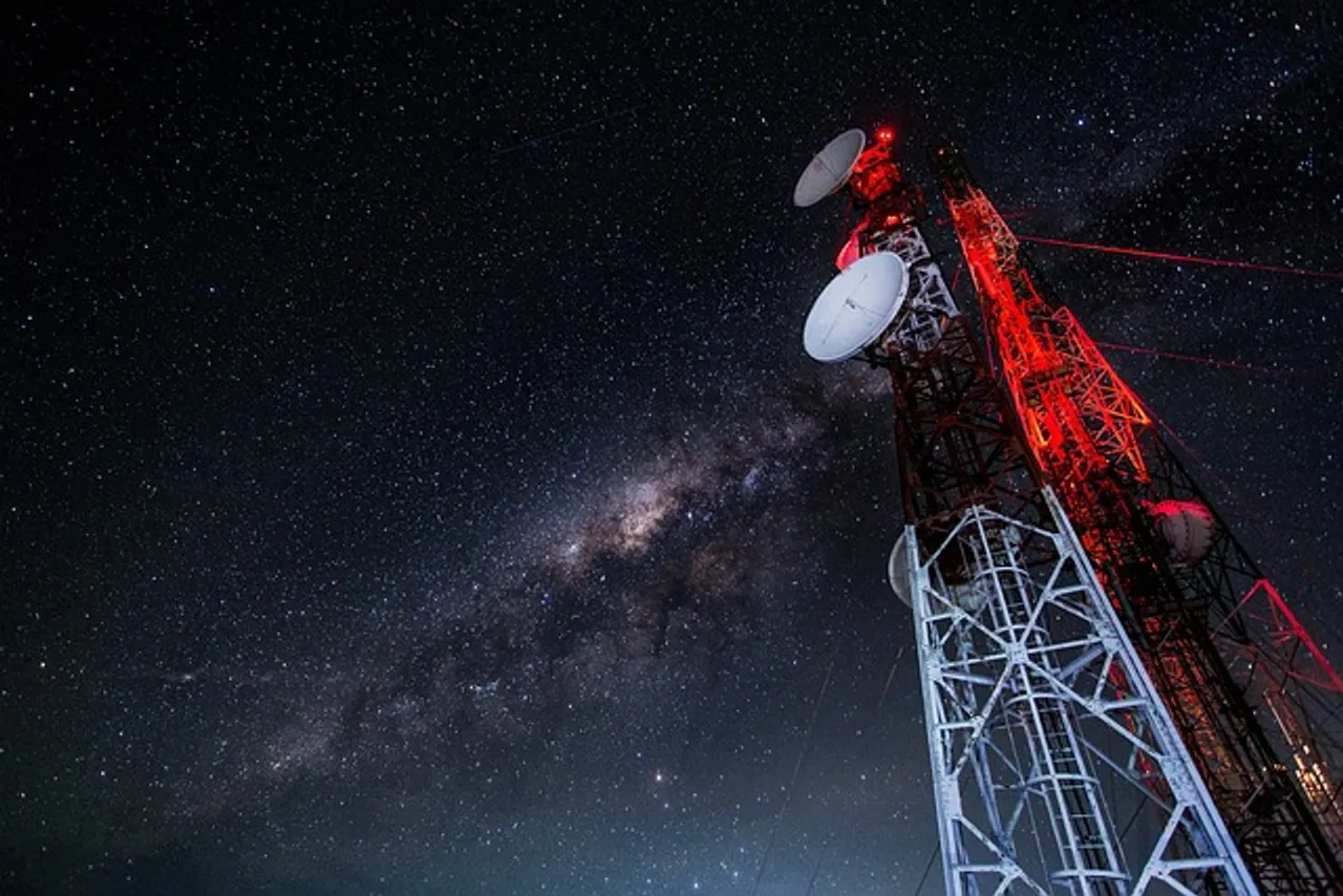 A tall tower with a red light shining at the top.