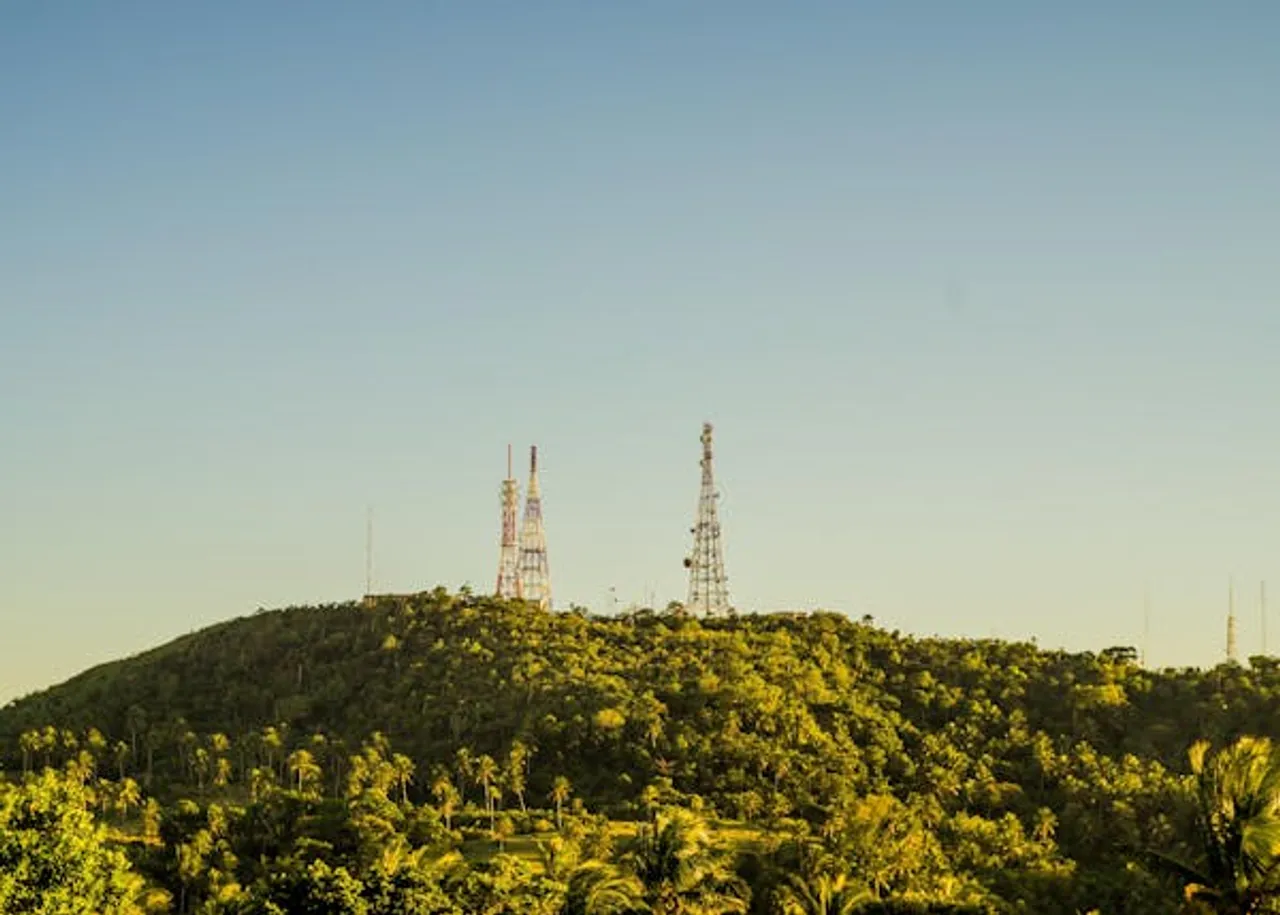 Two towers standing tall on a hill, surrounded by lush trees.