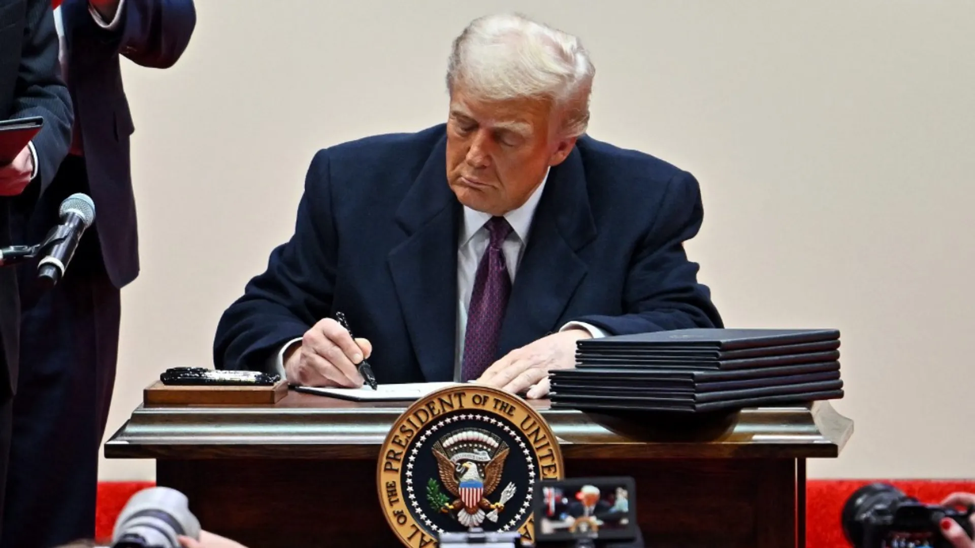 US President Donald Trump signs executive orders during the inaugural parade inside Capital One Arena, in Washington, DC, on January 20, 2025.