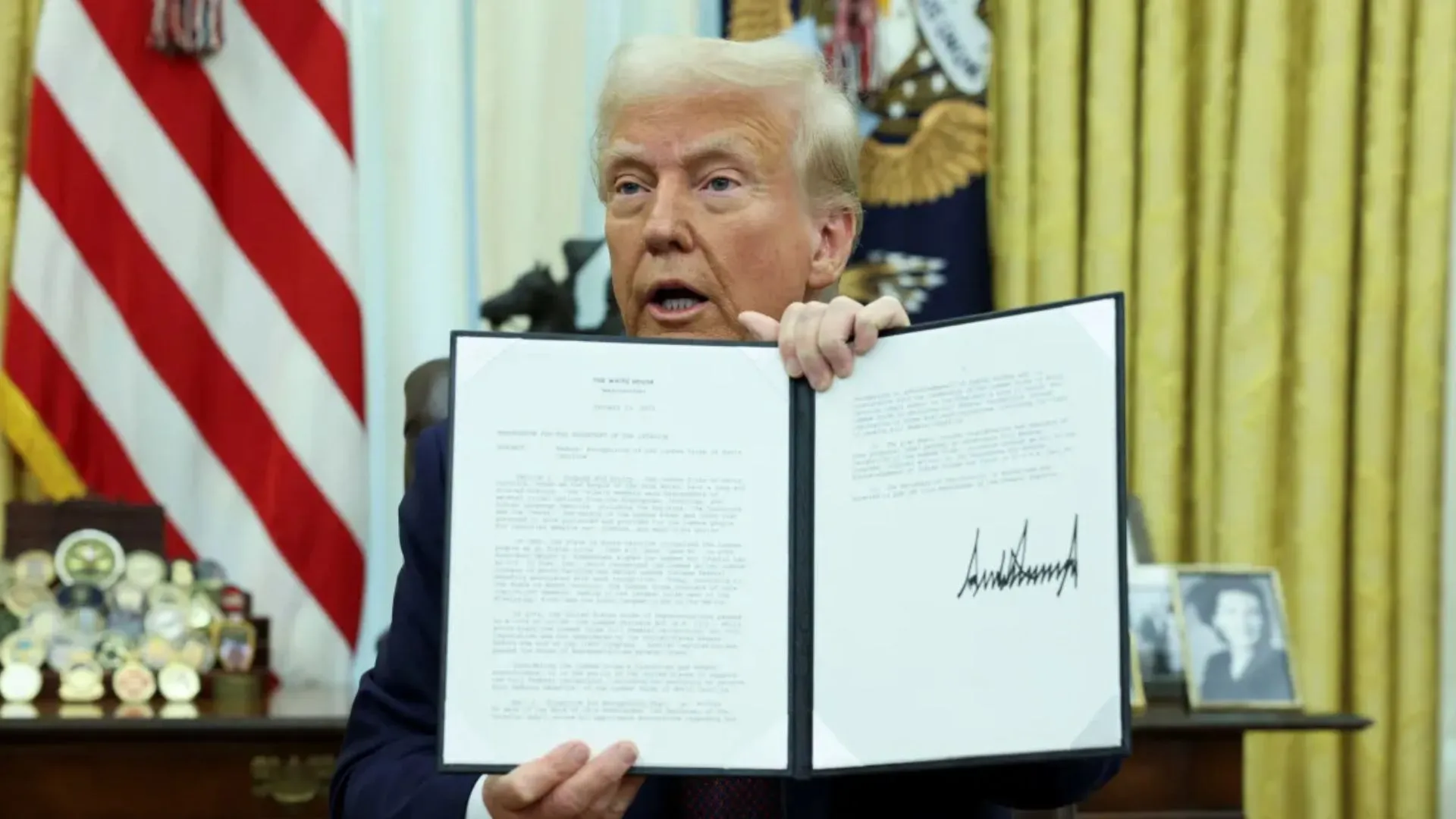 U.S. President Donald Trump holds a signed executive order on cryptocurrencies in the Oval Office of the White House in Washington on Jan. 23