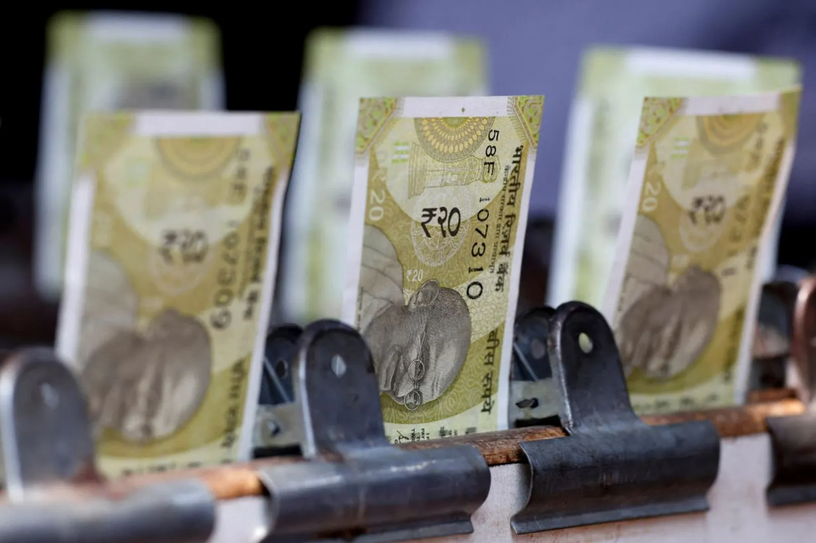 Indian twenty rupee currency notes are displayed at a roadside currency exchange stall in New Delhi, India