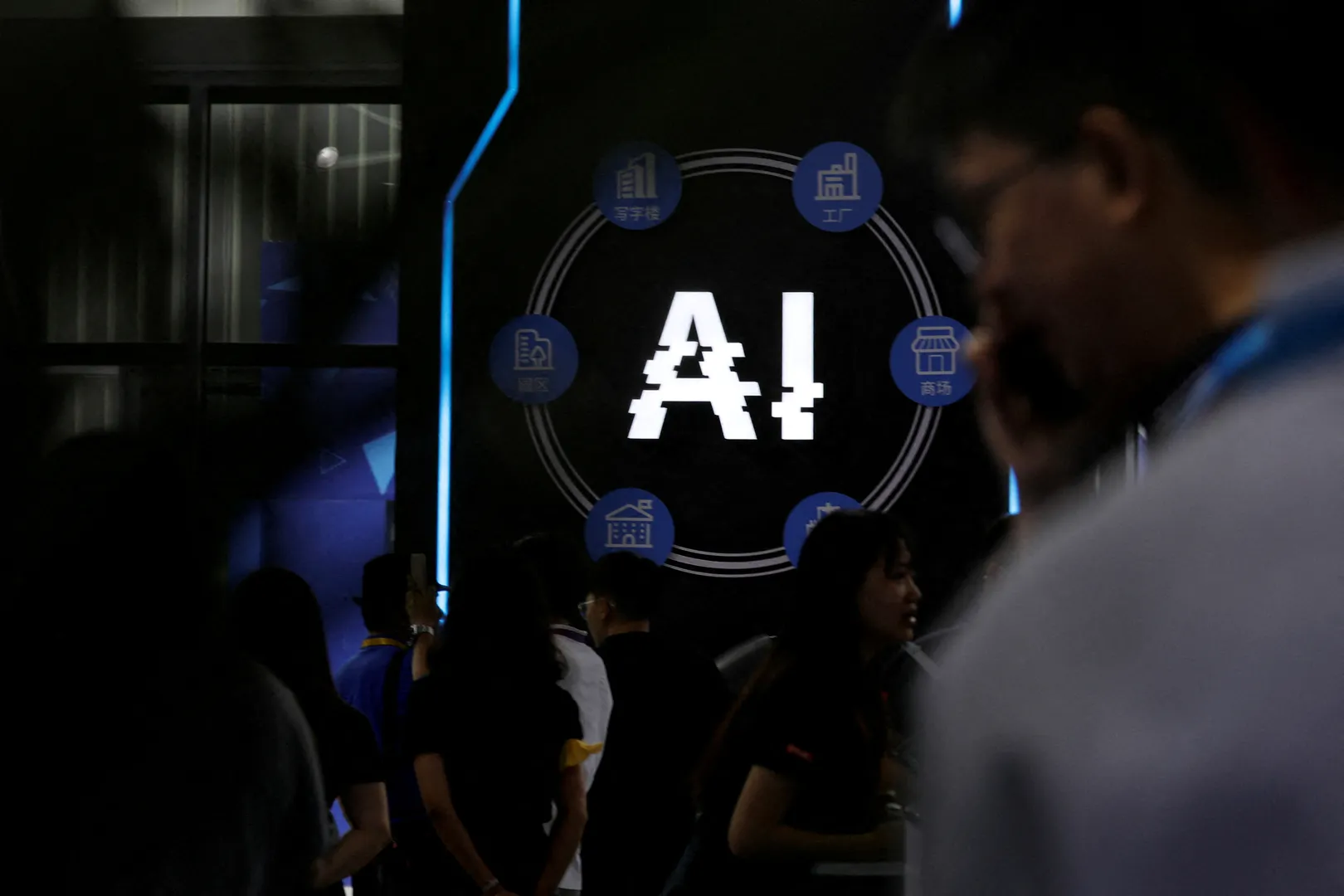 Visitors stand near a sign of artificial intelligence at an AI robot booth