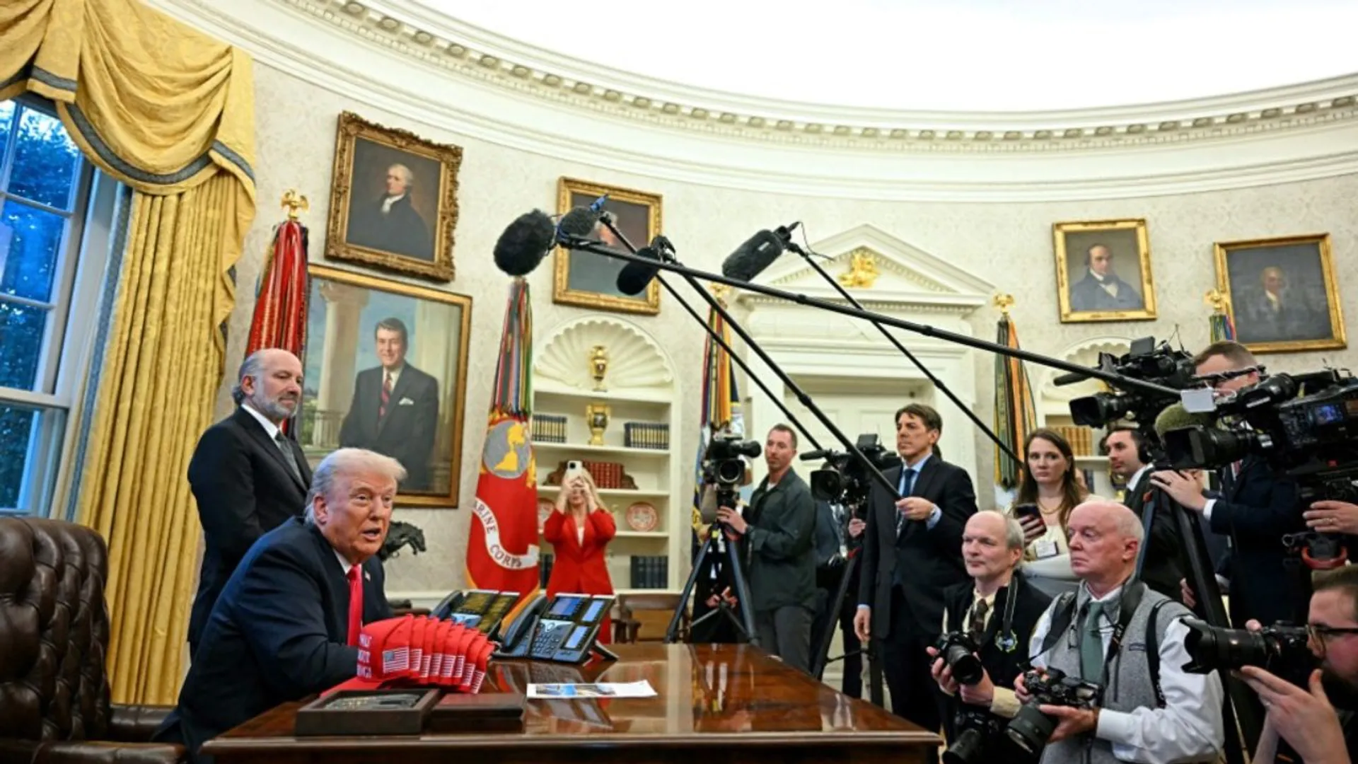 US President Donald Trump speaks to the press next to hats reading 'Trump was right about everything', after signing an Executive Order at the Oval Office of the White House in Washington, DC on February 25, 2025.