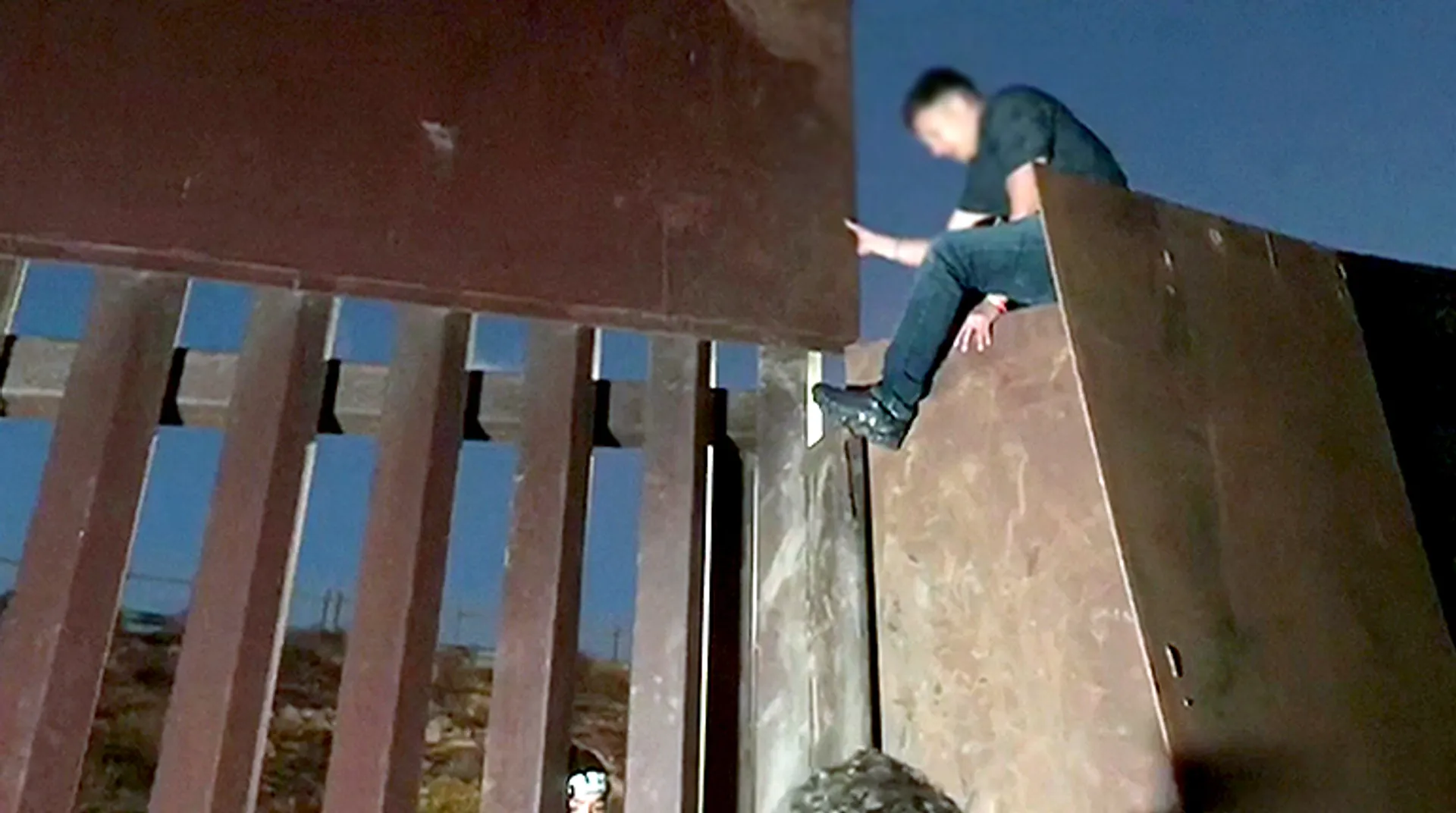 Watch: Migrants jump US-Mexico border fence at night