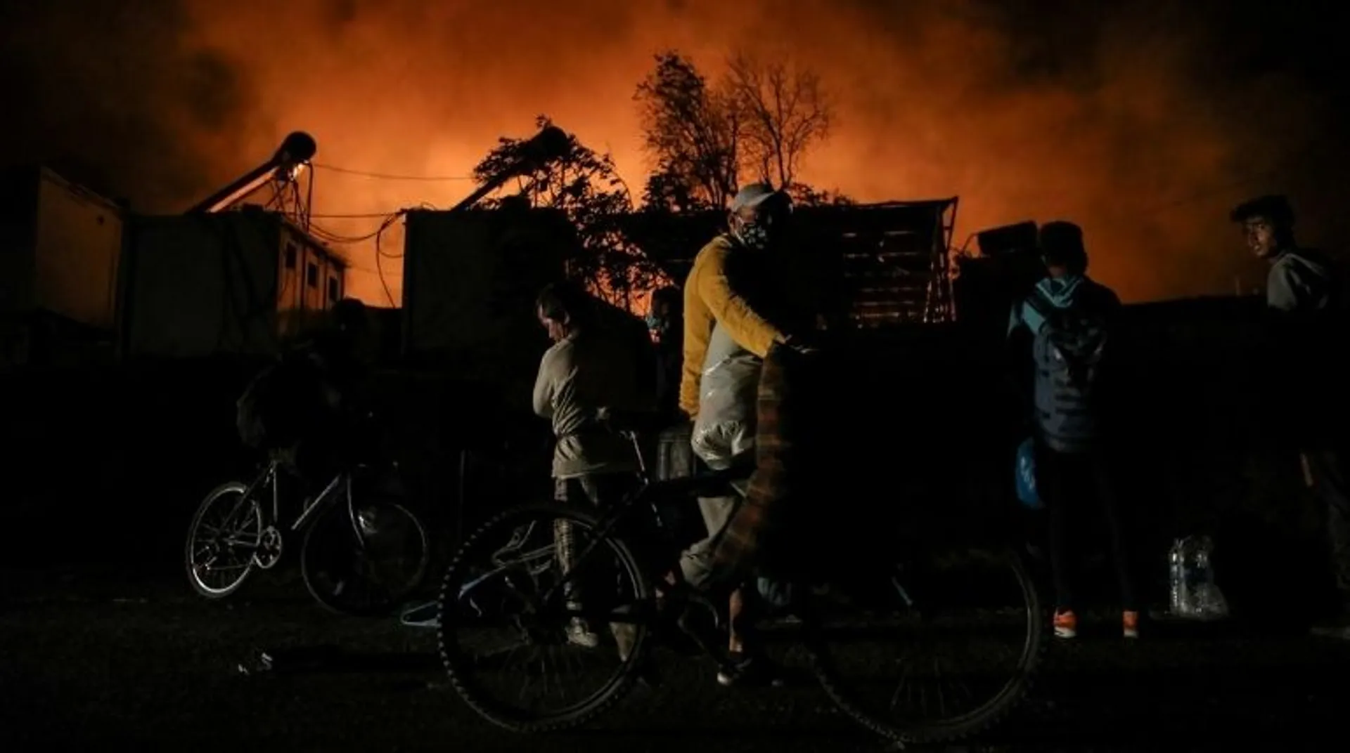 Greek police transfers migrants to temporary tent after fire destroys camp