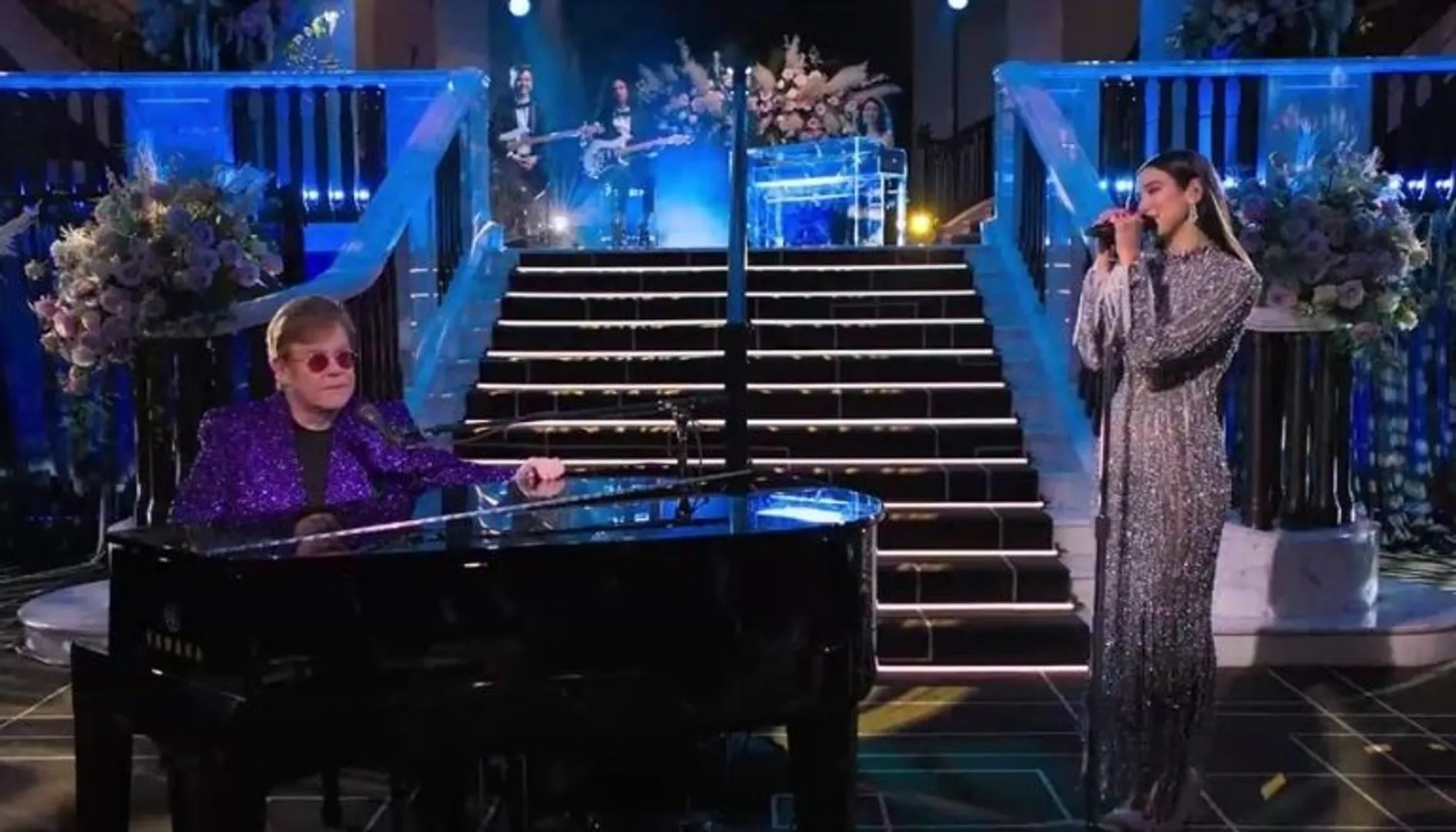 Dua Lipa sparkles in a metallic dress as she performs at Elton John's annual Oscar party