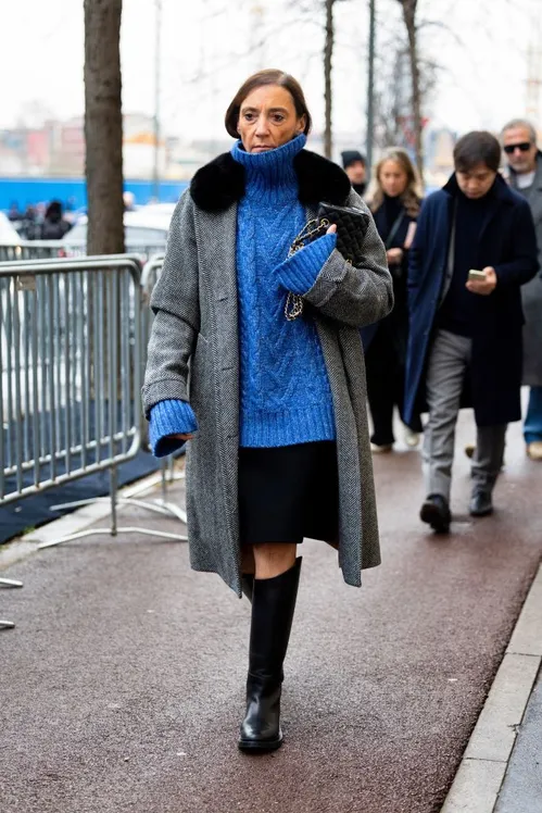 milan, italy january 19 a guest wears a grey coat with black fur applications, a light blue knitted turtle neck oversized sweater, a black skirt, a black leather bag and black leather knee high boots outside prada show during the milan fashion week menswear fallwinter 2025 2026 on january 19, 2025 in milan, italy photo by valentina frugiuelegetty images