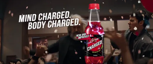 A bottle of soda with a person in the background

Description automatically generated