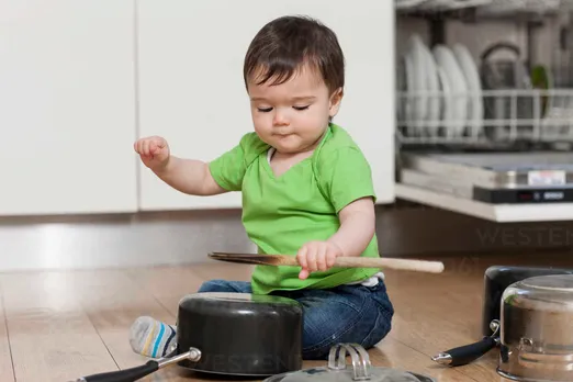 Baby playing with pots and pans stock photo