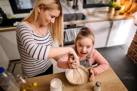 Daughter with Down syndrome helps her mother prepare pancakes