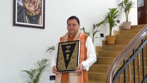 Uttarakhand Chief Minister Pushkar Singh Dhami leaves from his residence with a copy of the Constitution, in Dehradun