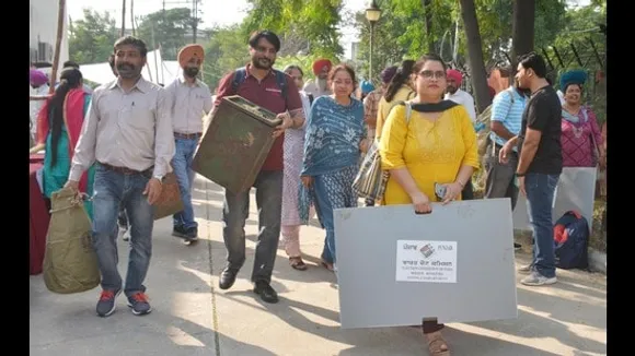 সোমবার অমৃতসরে গ্রাম পঞ্চায়েত নির্বাচনের প্রাক্কালে ভোটগ্রহণ কর্মকর্তারা তাদের নিজ নিজ ভোটকেন্দ্রে যাওয়ার আগে ভোটদানের উপকরণ বহন করছেন। (সমীর সেহগাল/হিন্দুস্তান টাইমস)