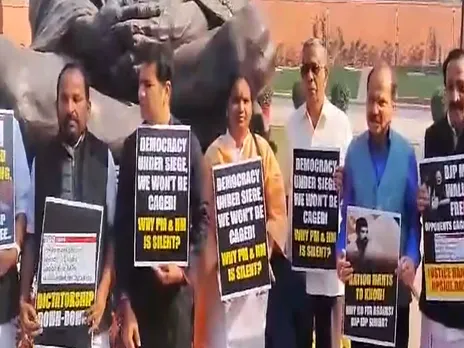 Opposition MPs stage a protest in front of the Gandhi statue