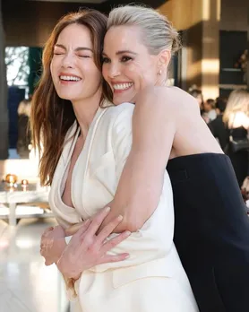 two women posing together with an embrace at an event