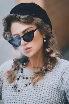 stylish young woman smoking on street