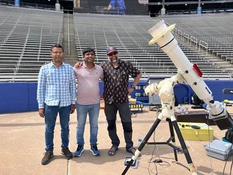 Team ARIES seen standing near a telescope, ahead of the total solar eclipse on Monday.