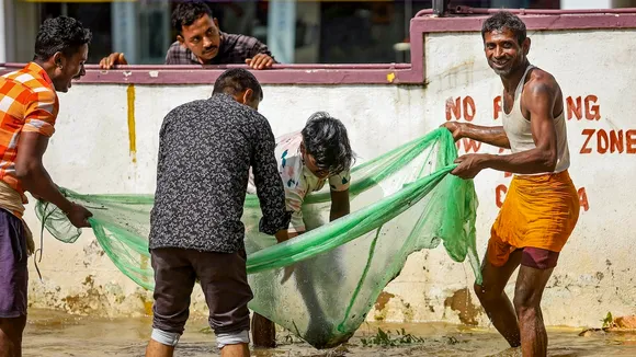 People catch fish in a waterlogged area after heavy rain, at Yelahanka old town in Bengaluru, Tuesday, Oct. 22, 2024.
