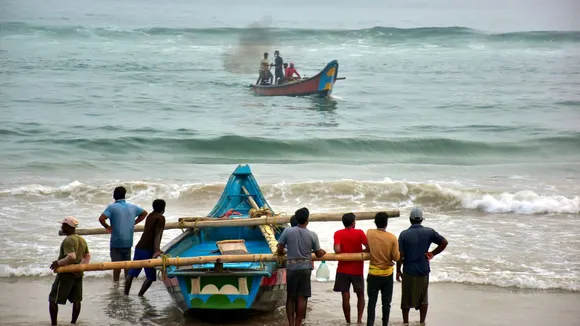 Fishermen shift their boats in preparations for Cyclone Dana, in Puri