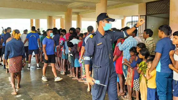 Affected people wait in queue as Navy personnel distribute relief materials in the aftermath of cyclone 'Dana', at an affected village in Kendrapara district of Odisha, Saturday, Oct 26, 2024.