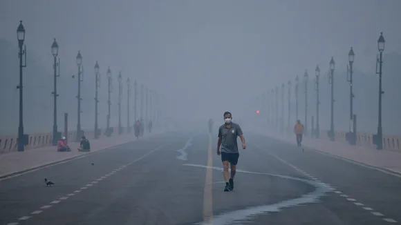 A pedestrian at Kartavya Path amid smog, in New Delhi