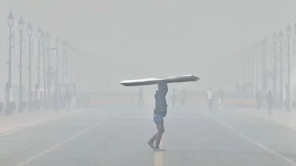 A worker at Kartavya Path amid low visibility due to smog, in New Delhi