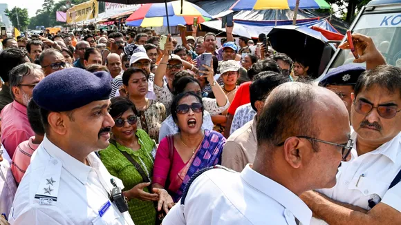 Security personnel stand guard as people protest near junior doctors' hunger strike 'manch' against the alleged rape and murder of a trainee doctor, in Kolkata, Friday, Oct. 11, 2024.