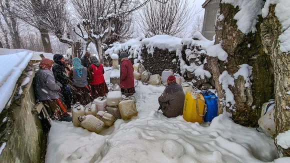 Residents collect drinking water from a tap during snowfall at Rashel village, inLahaul and Spiti district, Sunday, Feb. 4, 2024.