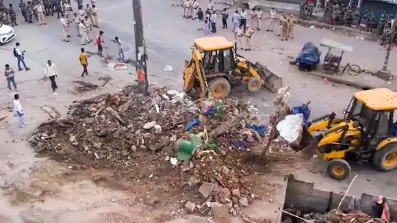 Bulldozers being used to demolish two religious structures for the construction of a flyover, during a drive by PWD, at Bhajanpura area in New Delhi, Sunday, July 2