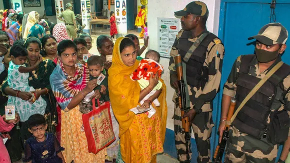 People wait in queues to cast their votes at a polling station during the 3rd phase of Lok Sabha polls, in Malda district, Tuesday, May 7, 2024