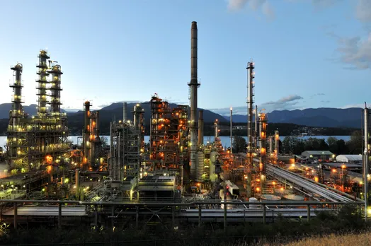 View of an oil refinery, with mountains in the background