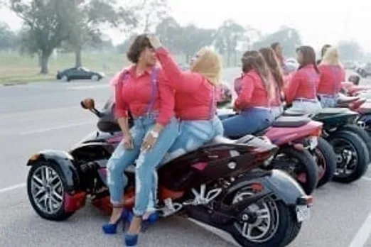 Women riding motorbike.