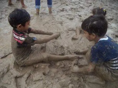 Children playing with wet sand.