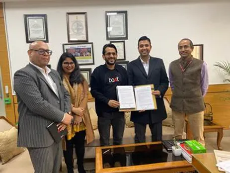 A group of people standing in a room holding a piece of paperDescription automatically generated