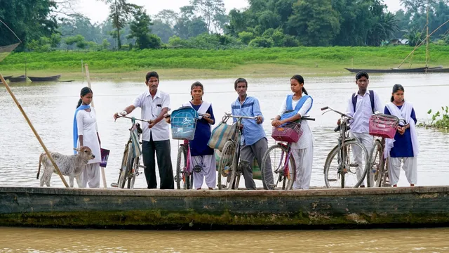 School students and others take a boat ride across the Brahmaputra River, in Morigaon district