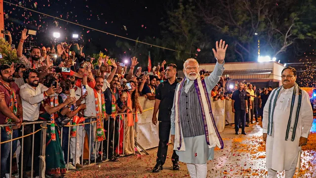 Prime Minister Narendra Modi with BJP National President JP Nadda waves to the crowd at BJP headquarters