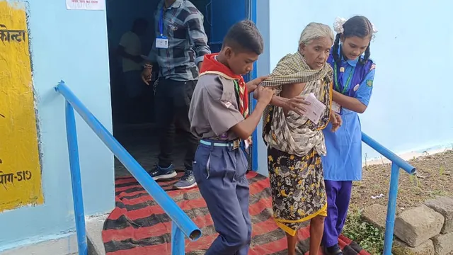 An elderly voter being assisted as she arrives to cast her vote for the 1st phase of Chhattisgarh Assembly elections, in Sukma district