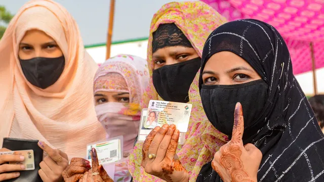 Burqa-clad women show their inked fingers after casting votes at a polling station during the third phase of Lok Sabha elections in Bareilly, Tuesday, May 7, 2024.