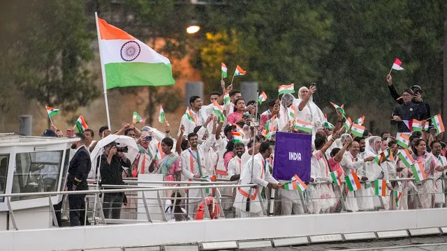 Indian athletes wave the national flags from a boat on the Seine River during the opening ceremony of the Paris 2024 Olympic Games, in Paris, France, Friday, July 26, 2024.